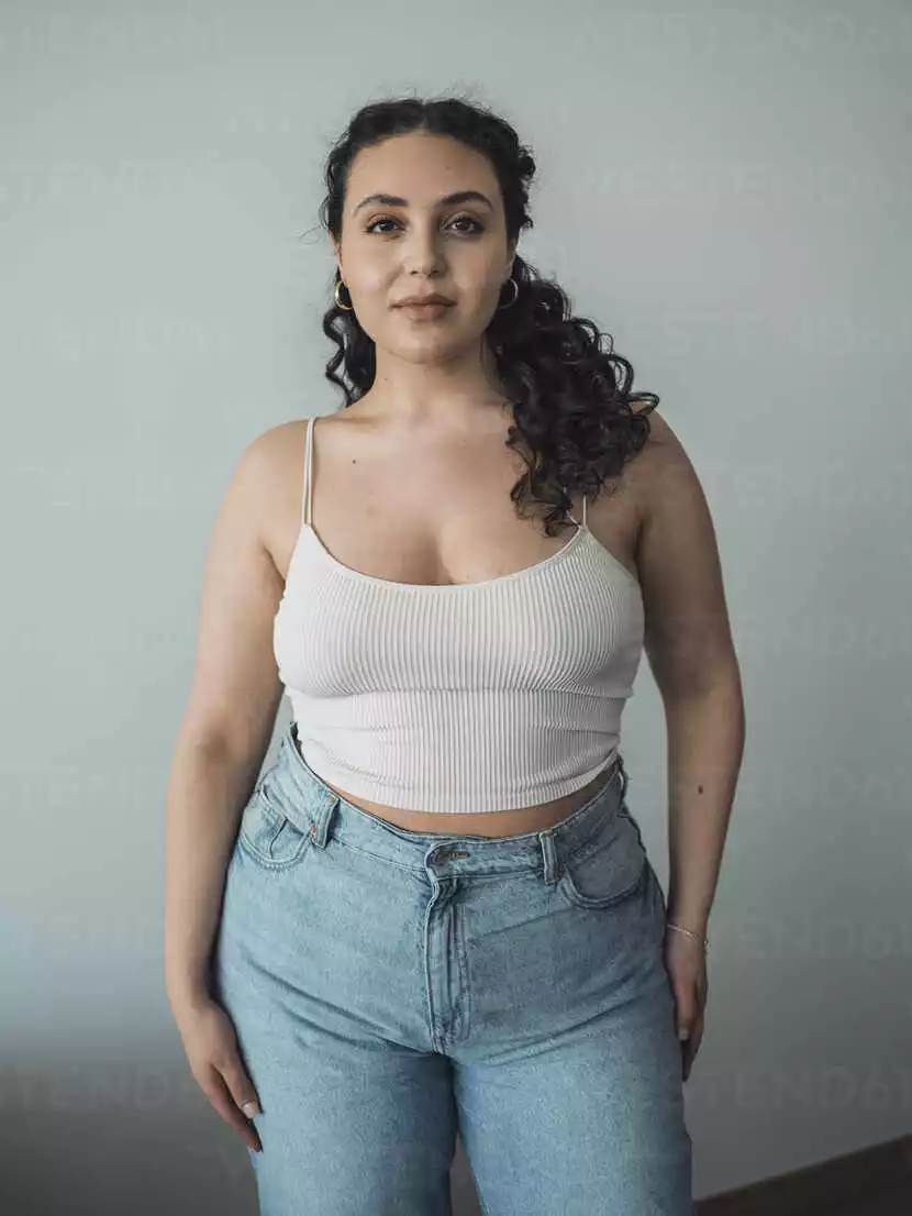 confident-curvy-woman-standing-in-front-of-wall-MFF09376.webp