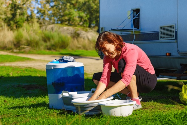 woman-doing-laundry-on-vacation-600nw-2182109409.jpg